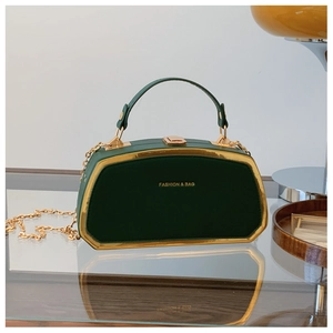 Dettaglio borsa a mano verde scuro con cornice in metallo dorato e tracolla a catena