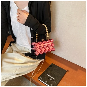 Pink acrylic box bag with mirror finish spheres and golden beaded handle detail