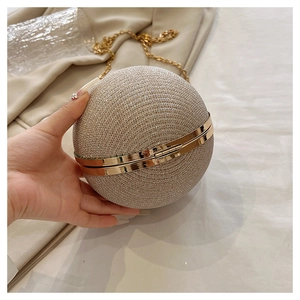 Gros plan sur la pochette sphérique à paillettes champagne avec bandoulière en chaîne dorée