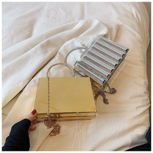 Detail of metallic acrylic clutch bags with gold smooth and silver pleated textures