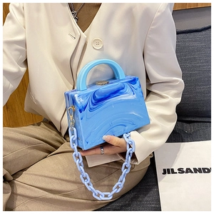 Detail of blue marble acrylic box bag with chunky chain strap and stylish handle