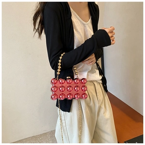 Detail of pink bubble texture acrylic bag with gold ball handle and chain strap