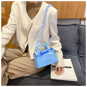 Blue marble acrylic box bag with chunky chain strap and top handle held by a model