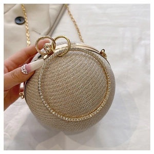 Détail de sac de soirée sphérique avec paillettes champagne et poignée anneau strass