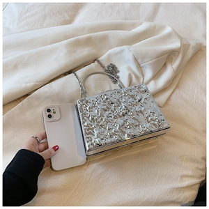 Silver metallic box bag with lava texture shown next to a smartphone for size scale