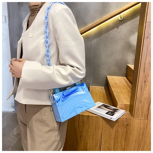 Detail view of blue marble acrylic clutch with thick light blue chain on a model