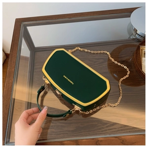 Vista dall'alto della pochette in pelle verde scuro con catena e cornice dorata