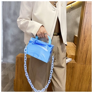 Detail of blue marble acrylic crossbody bag with thick chain strap and top handle