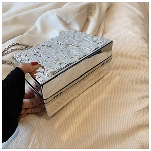 Macro view of silver acrylic box bag featuring unique lava texture and metal chain strap