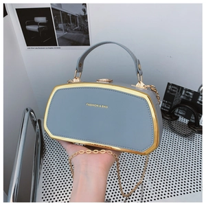 Dettaglio della borsa a scatola azzurra con cornice in metallo dorato e scritta Fashion Bag