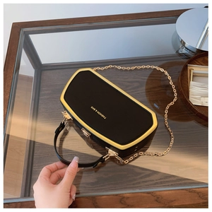 Dettaglio elegante borsa a scatola nera con cornice in metallo dorato e scritte