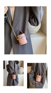 Detailed macro view of pink pebbled leather bucket bag with gold chain and heart patch