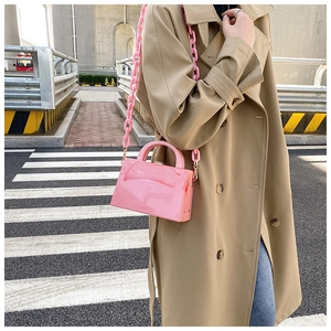 Close-up of pink jelly crossbody bag with chunky acrylic chain strap and polished finish