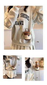Detail view of mini bucket bag with chain strap shown on model for scale and styling