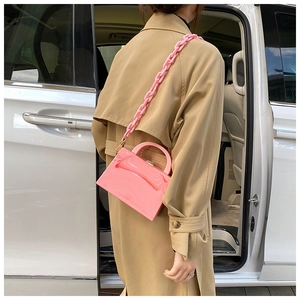 Detailed side view of a pink acrylic box bag with a thick chain strap on a model