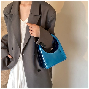 Sac croissant en acrylique bleu effet miroir métallisé porté par un mannequin chic