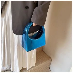 Détail du sac à main en acrylique bleu électrique avec finition miroir et poignée ronde