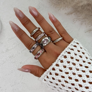 Detailopname van zilveren boho ringenset met roze en paarse edelstenen op hand
