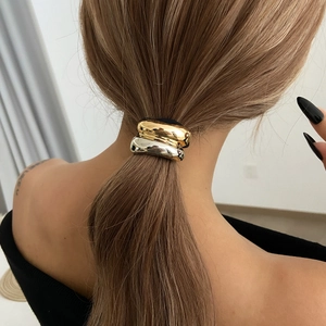 Detail of gold and silver metallic dual-tone hair tie on a model ponytail hairstyle