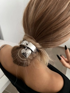 Close-up of a silver heart pendant hair accessory on a minimalist hairstyle