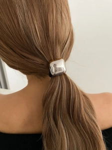 Close-up of a minimalist silver geometric metal hair ring on a woman's ponytail