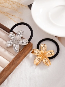 Detailed view of gold and silver metal flower charms on black elastic ponytail holders