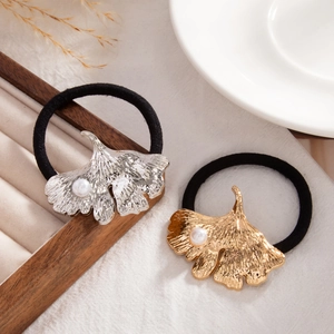Detail of gold and silver ginkgo leaf hair ties with pearl centers and veined texture