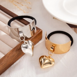 Detail view of heart pendants on hair ties in gold and silver finishes on velvet