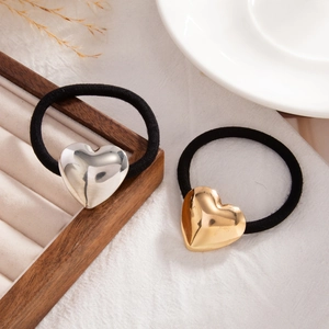 Detailed view of high-elastic black hair ties with polished gold and silver heart charms
