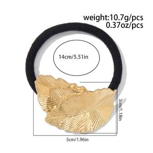Détail d'élastique à cheveux feuille dorée avec bande noire et texture métallique