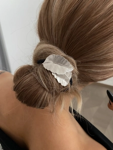 Détail d'un élastique à cheveux feuille argentée montrant le design sur une queue