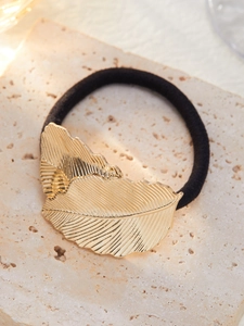 Détail de l'élastique noir avec décoration en feuille de métal doré texturé et chic