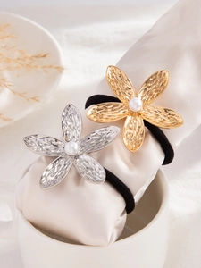Detail van metalen bloem haarelastiekjes met hamerslag en parels in goud en zilver