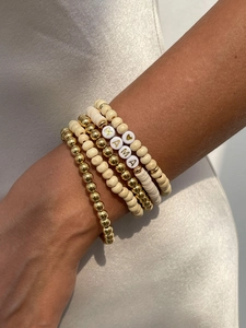 Detail of stacked bohemian bracelets with MAMA letter beads and wooden accents