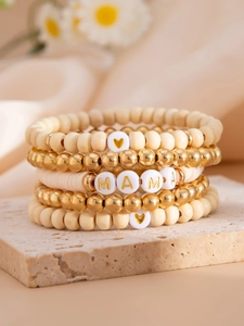 Macro detail of 5-layer bohemian beaded bracelet with gold MAMA letters and heart charms