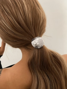 Silver geometric ponytail holder with a textured checkered design on brown hair