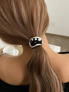 Close-up of a ponytail hair tie featuring irregular silver metal and three white pearls