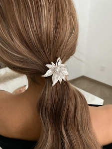 Detail of silver leaf hair tie with white pearl on a high-elastic black ponytail holder