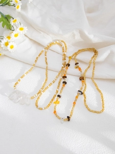 Detail view of handmade layered yellow beaded body chain with bohemia mineral stones