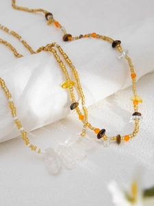 Detail of beaded waist chain with starfish pendants and raw white stones on soft fabric