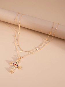 Macro view of gold-tone double-layered necklace with Byzantine cross and colorful gems