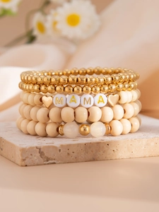 Detail view of 5-piece bohemian beaded bracelet set featuring MAMA letter beads and gold heart