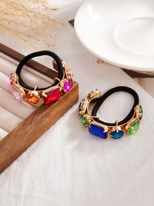 Detail of luxury hair ties with colorful geometric crystals and gold metal settings