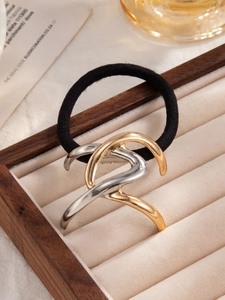 Detail view of stylish ponytail hair tie with gold and silver interlaced metal accent