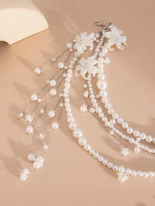 Detail of multi-layer pearl body chain with silver metal links and resin flower charms