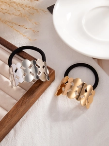 Close-up of gold and silver irregular hollow geometric metal hair ties on jewelry tray