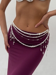 Detailed layered pearl body chain with silver links and fringe on a purple dress