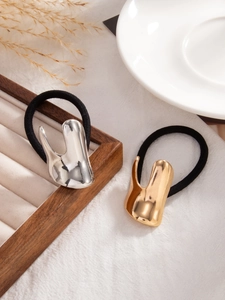 Close-up of liquid metal geometric ponytail holders in glossy gold and silver finishes