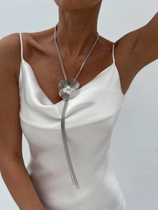 Détail du long collier argenté avec fleur en métal multicouche et pendentif perle