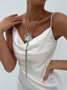 Vue détaillée du collier à pampilles fleurs argentées avec perle sur une robe en satin